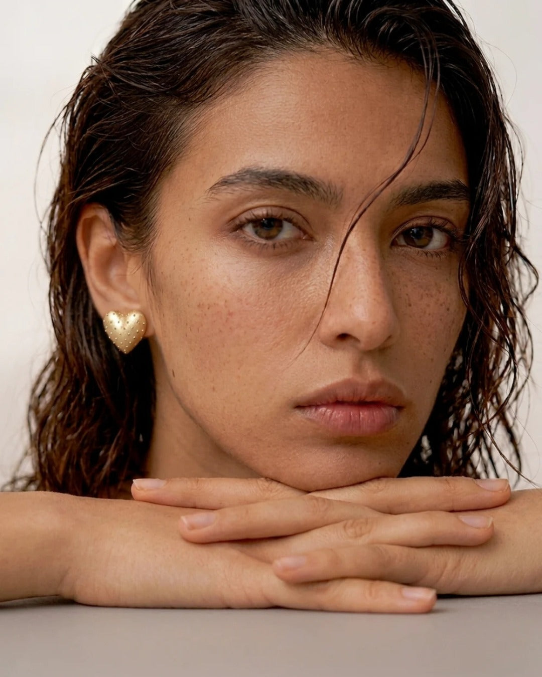 Woman wearing gold heart earrings for monsoon styling